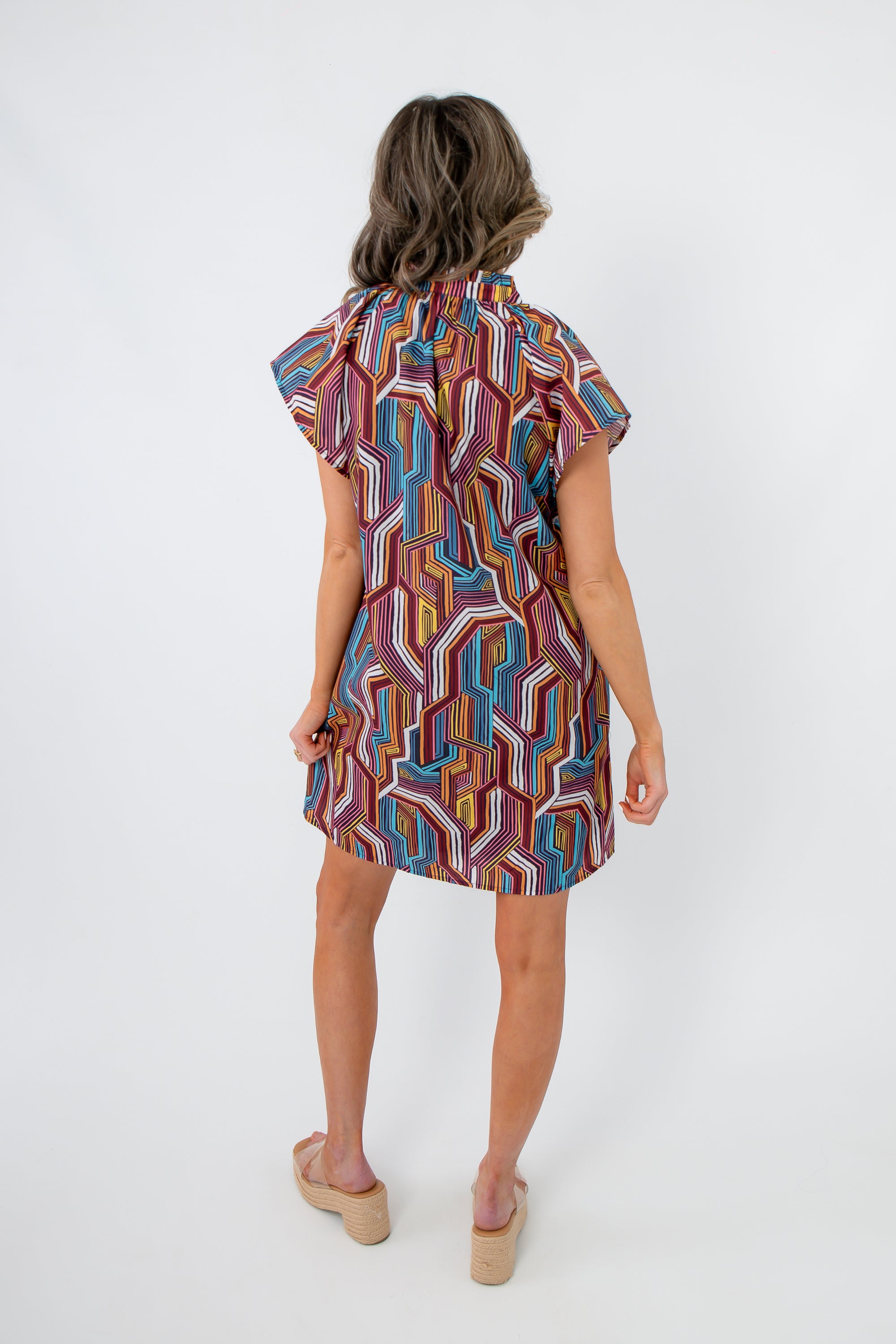 Back view of THML Tropadelic Short Sleeve Dress showing loose shift fit and bold tropical geometric stripe pattern for versatile styling.