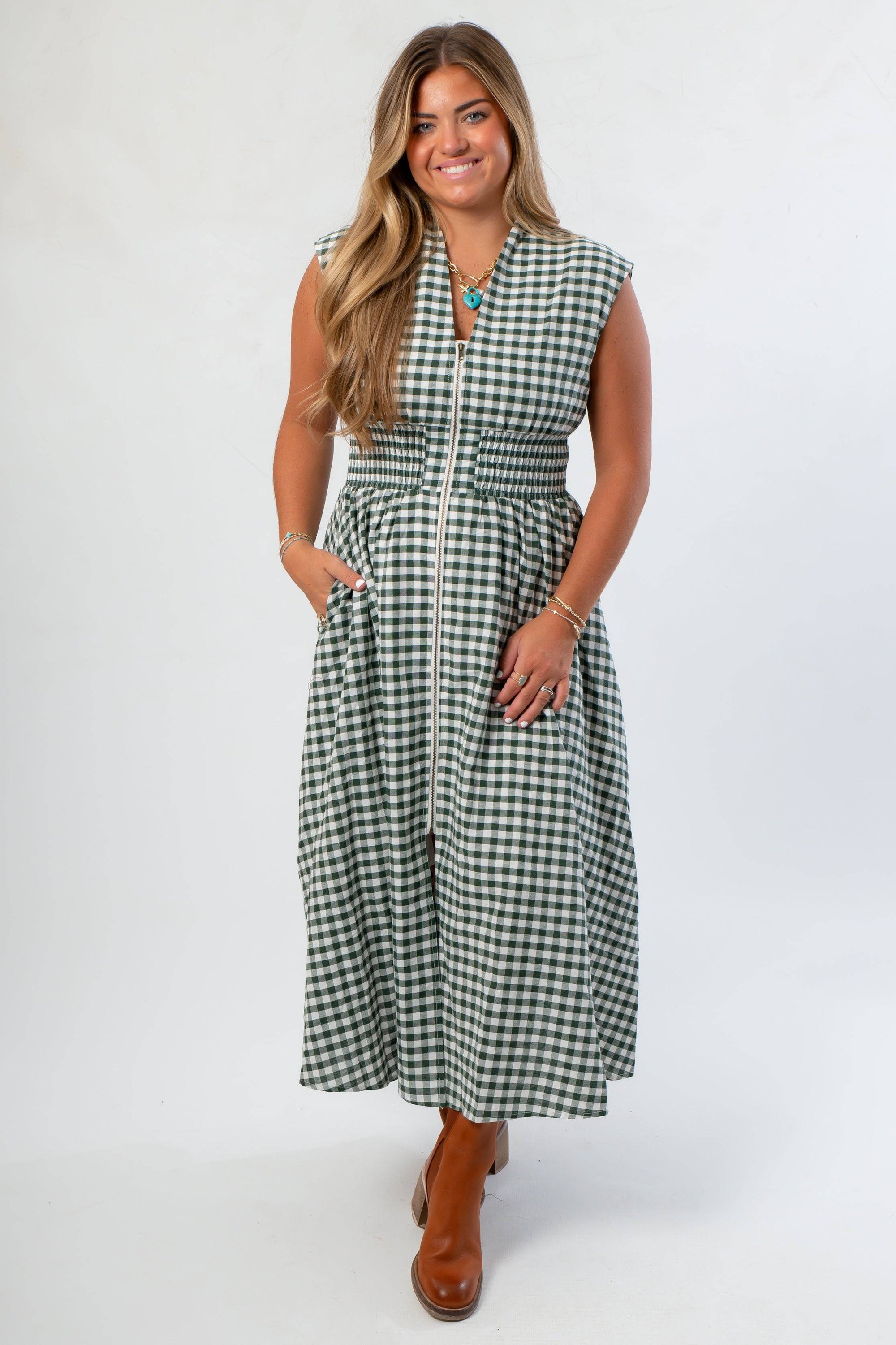 Stylish Pre-Fall Patch Season Green Gingham Midi Dress featuring front zip closure, side pockets, and flattering smocked waist design.