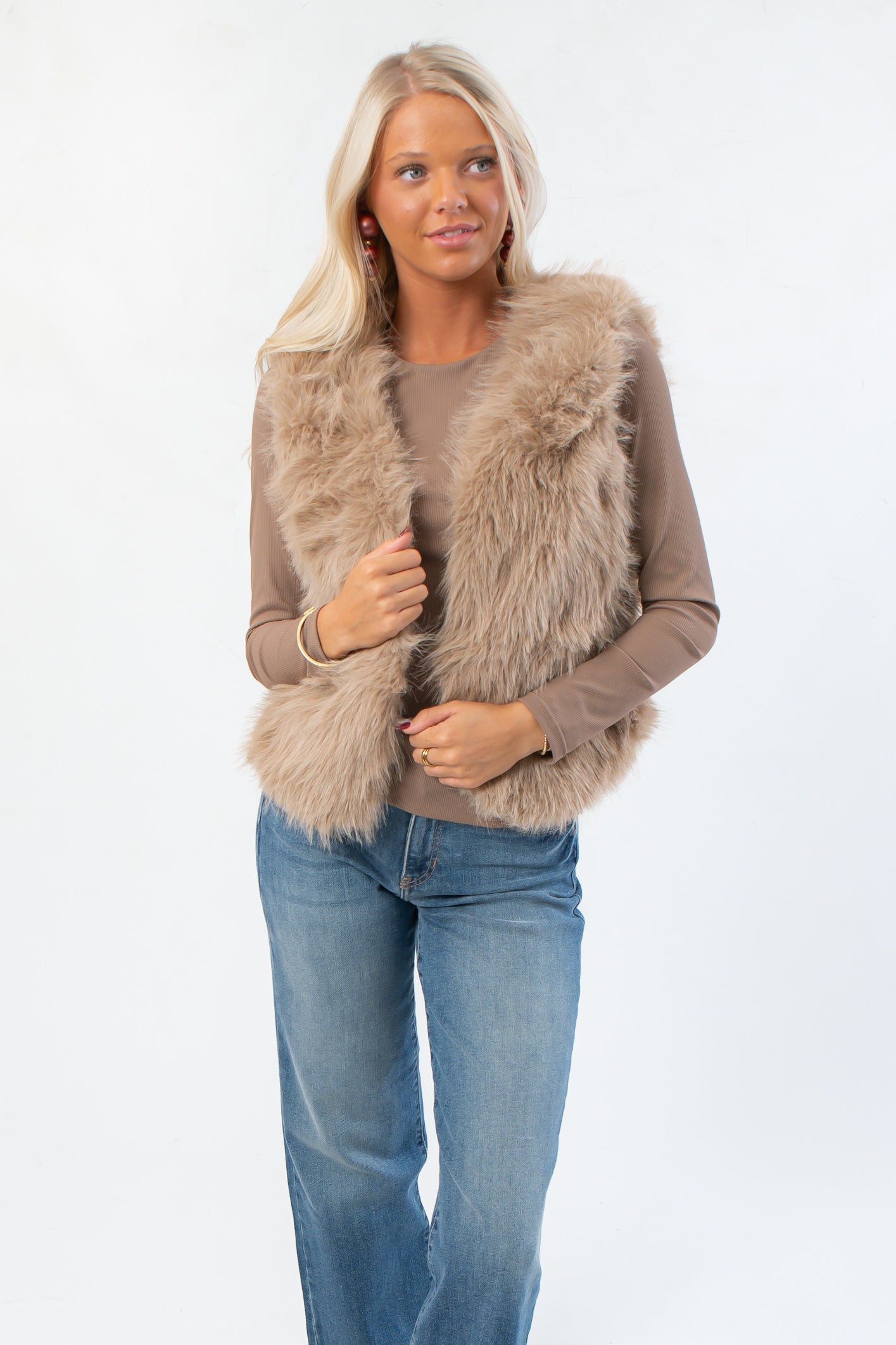 Fifth Avenue Taupe Faux Fur Vest with plush texture, styled over a taupe long sleeve top and jeans. Trendy women’s outerwear for fall layering.