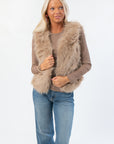 Fifth Avenue Taupe Faux Fur Vest with plush texture, styled over a taupe long sleeve top and jeans. Trendy women’s outerwear for fall layering.