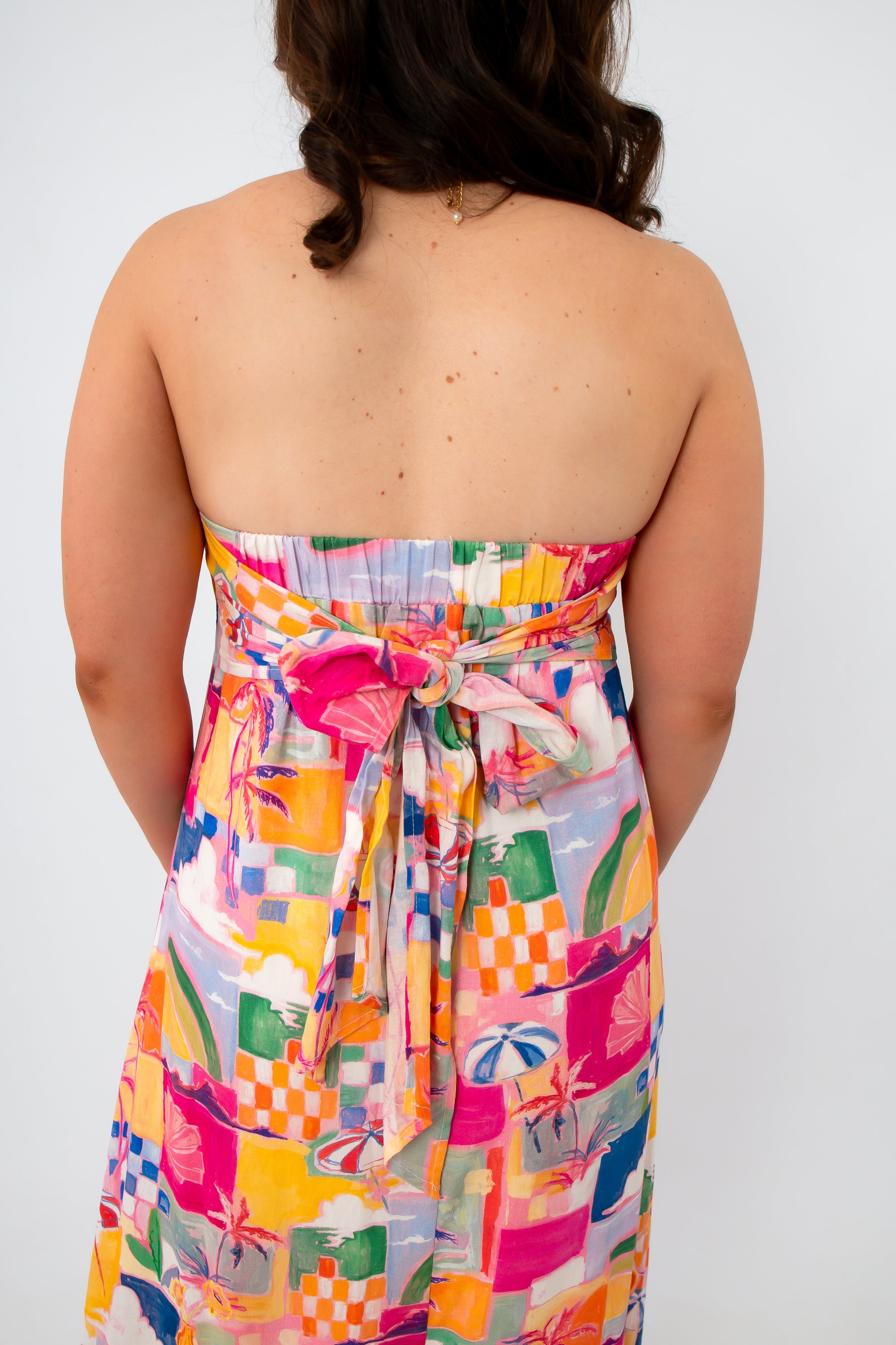 Back view of vibrant tropical print maxi dress with bow detail
