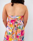 Back view of vibrant tropical print maxi dress with bow detail