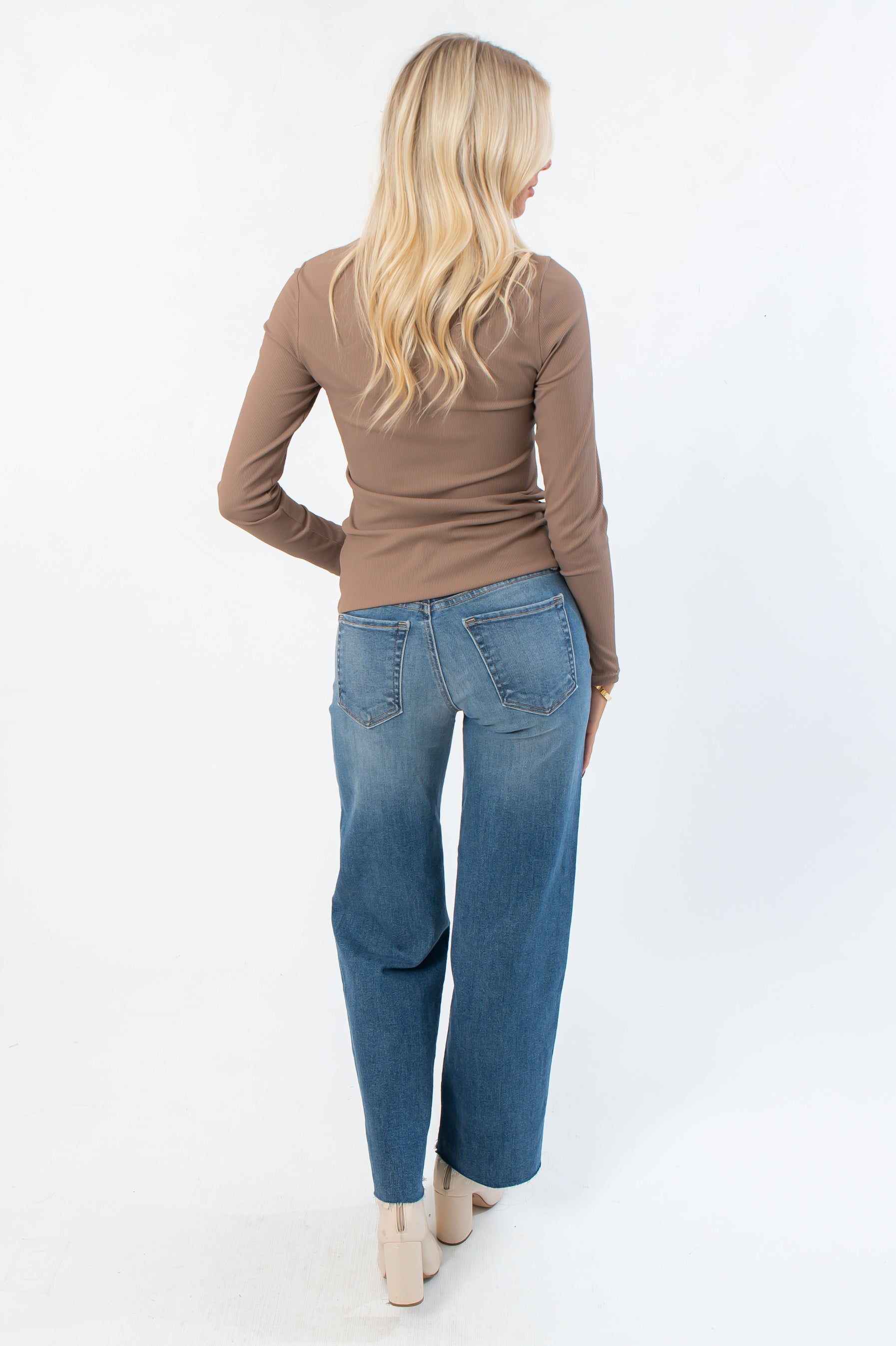 Back view of Roxi Ribbed Knit Top in clay taupe, paired with relaxed denim, highlighting its versatile boutique knitwear style.