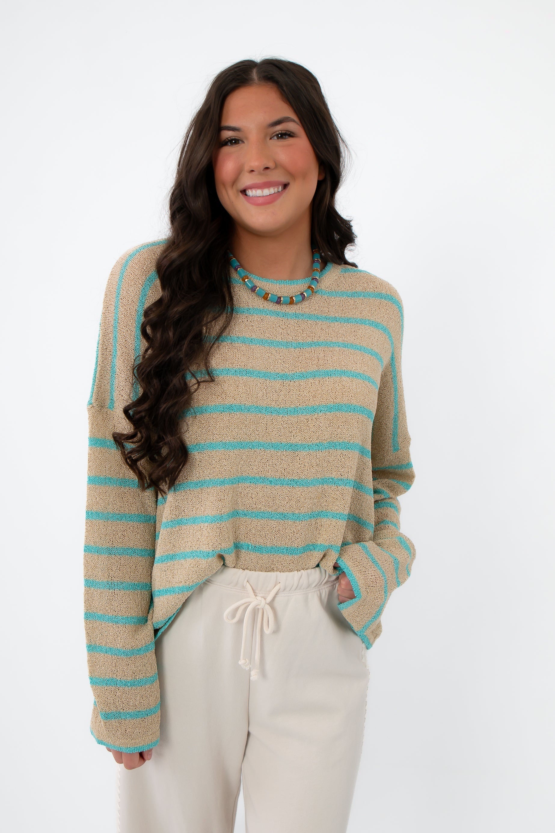 Coastal Spring Stripe Sweater – Lightweight mocha and aqua knit top with long sleeves, styled with cream drawstring pants for spring fashion.