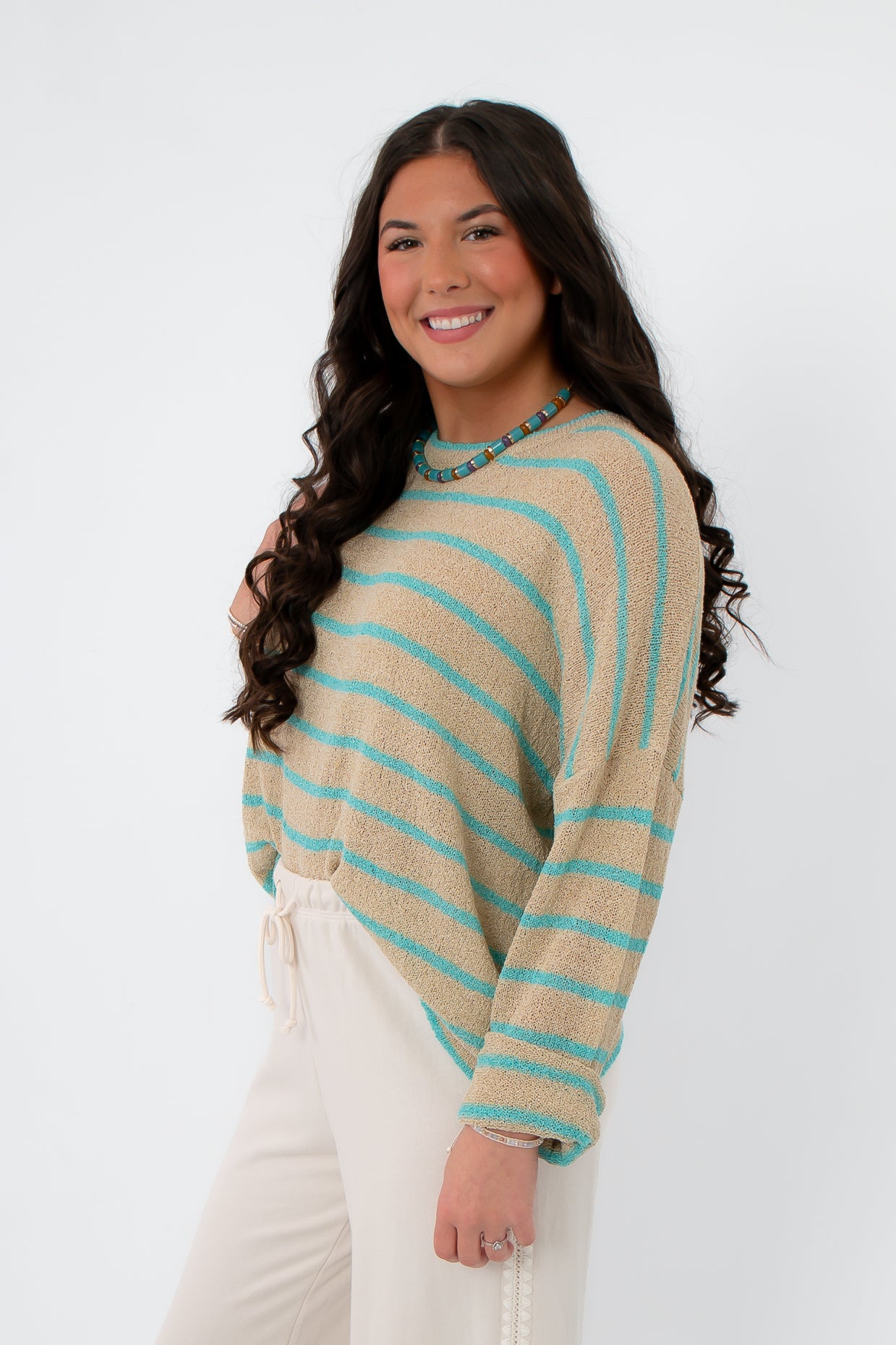 Side view of Coastal Spring Stripe Sweater in mocha and aqua stripes, showcasing its lightweight knit and loose silhouette for coastal style.