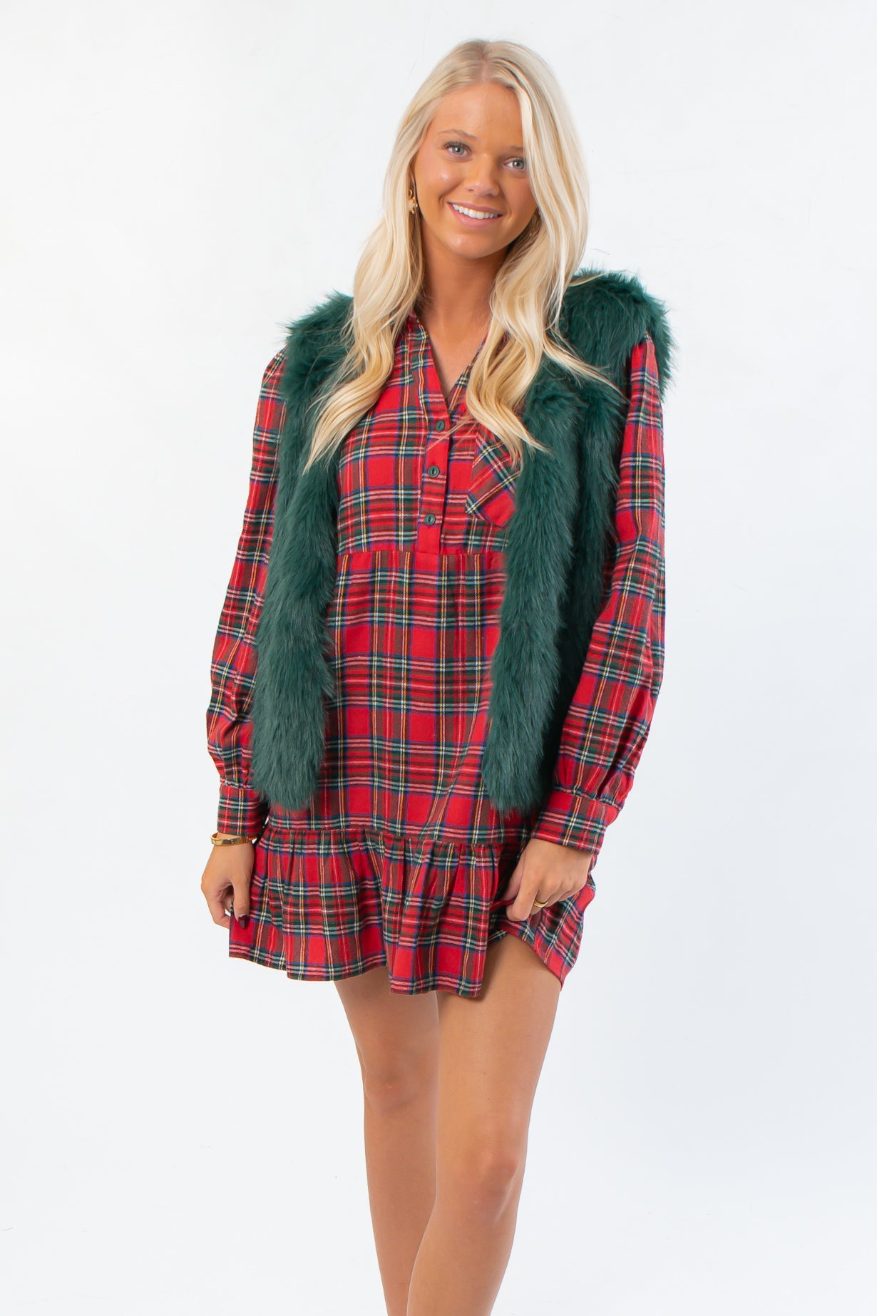 Frosted Pine Green Faux Fur Vest styled over a red plaid holiday dress, perfect for boutique winter fashion and festive layering.