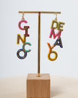 Colorful letter earrings on display stand
