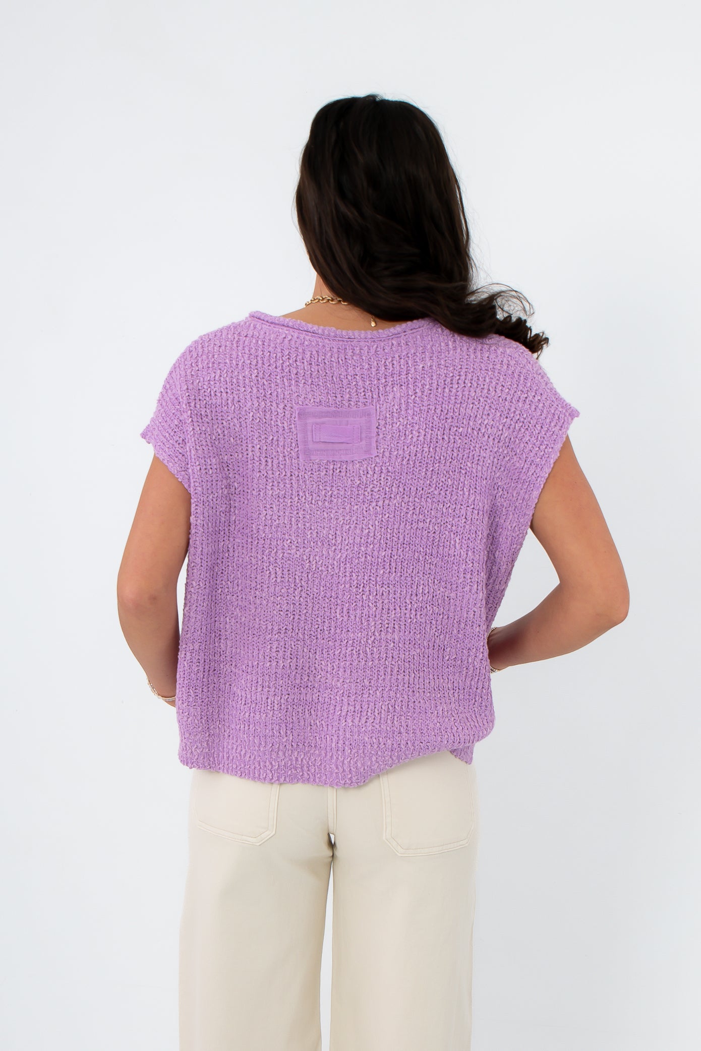 Back view of Wisteria Willow Short Sleeve Lilac Sweater featuring a patch detail and loose fit, a trendy pastel top for warm-weather layering.