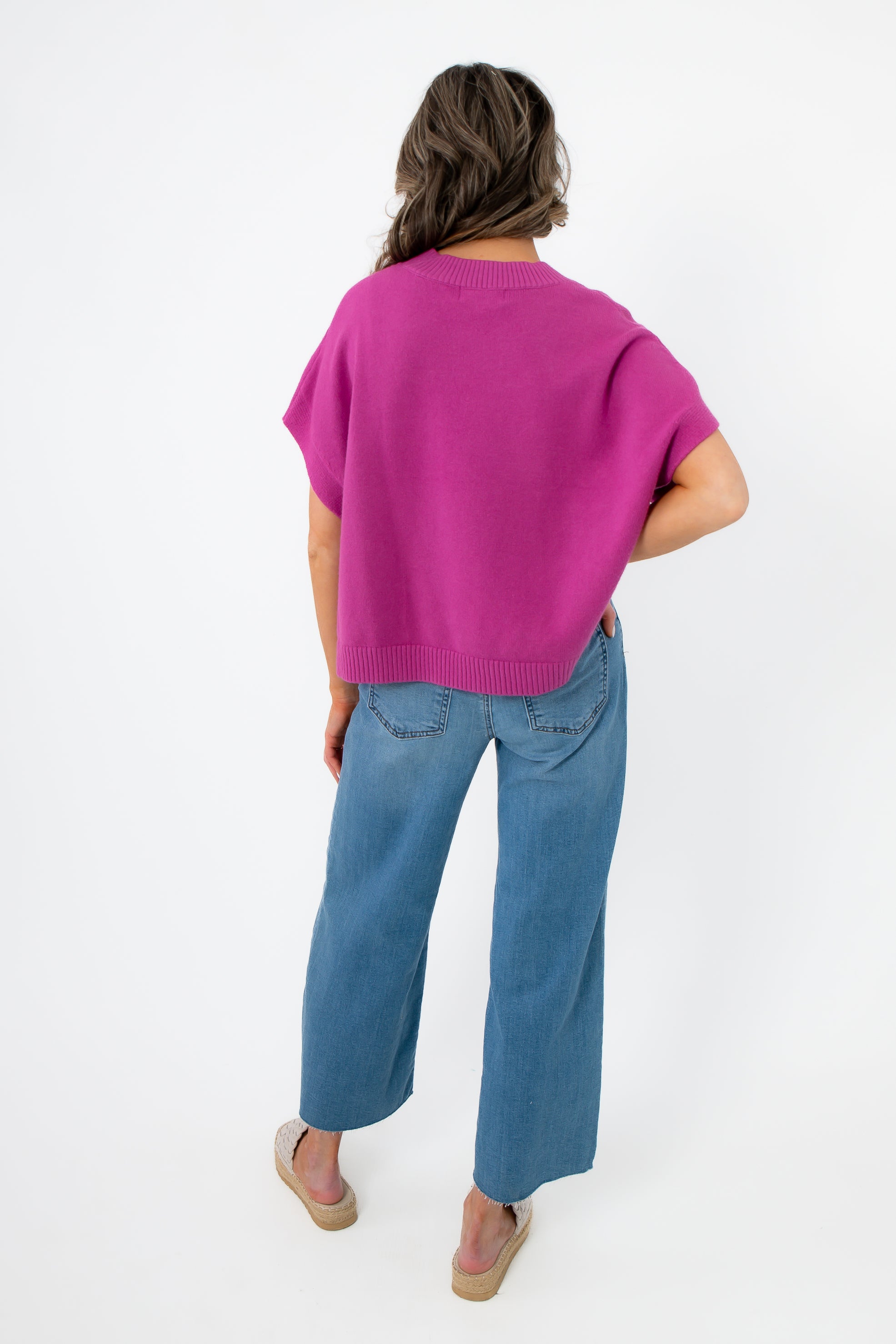 Back view of Whatever The Weather Orchid Sleeveless Sweater highlighting ribbed hem and relaxed silhouette. Chic purple knit top for modern wardrobes.