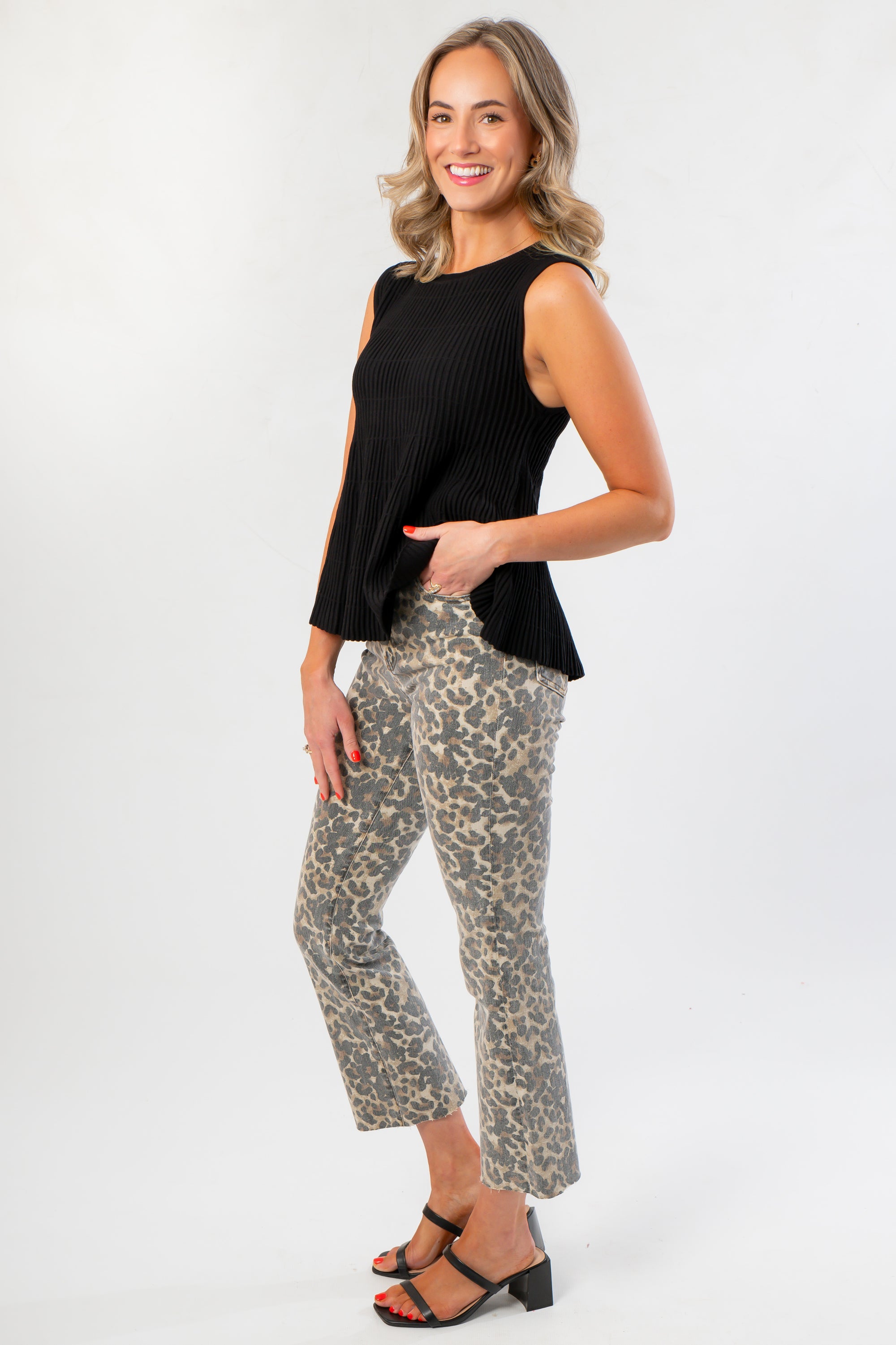 Side view of Kut Kelsey Leopard Ankle Flare Pants paired with heels, emphasizing the cropped flare leg and high-rise silhouette.