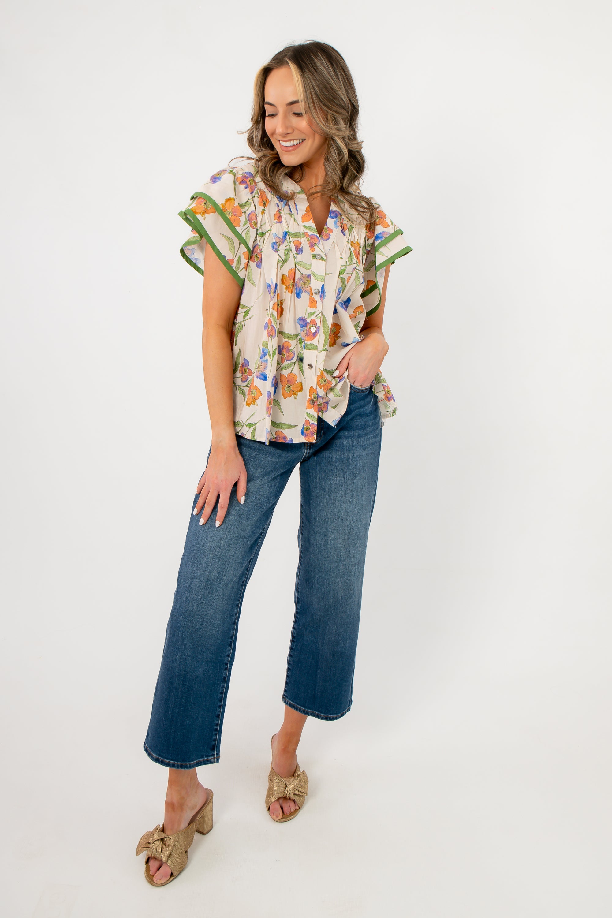 Ecru floral ruffle sleeve blouse styled with wide-leg jeans and heeled sandals, perfect for spring events or casual outings.