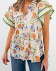 Close-up of Spring Fling Floral Ruffle Sleeve Blouse showing button-down front, vibrant floral pattern, and pleated detailing.