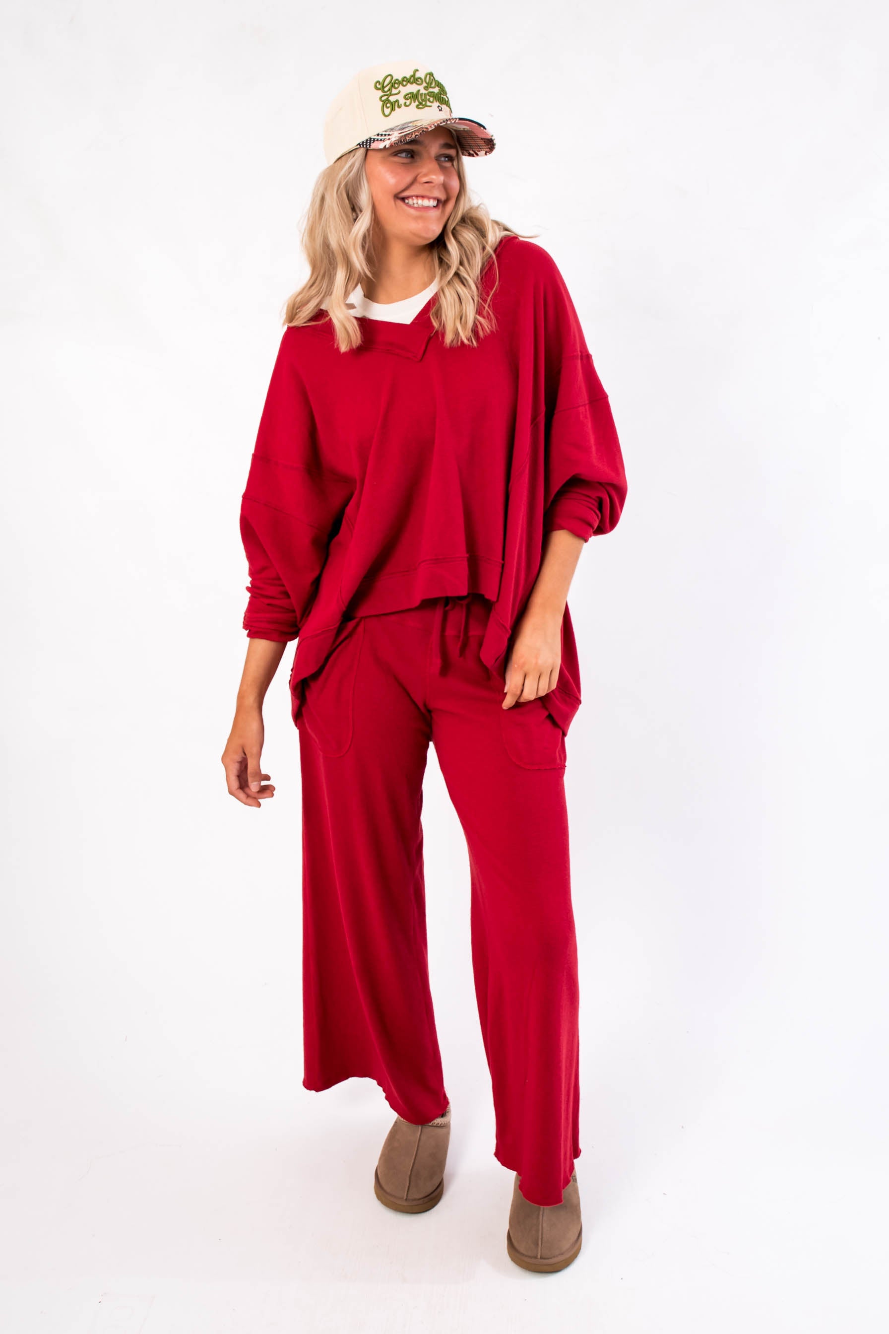 Free People Deep Cherry Staycation Pullover – Relaxed fit V-neck top in deep cherry, paired with wide-leg pants, ideal for layering or lounging.