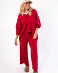 Free People Deep Cherry Staycation Pullover – Relaxed fit V-neck top in deep cherry, paired with wide-leg pants, ideal for layering or lounging.