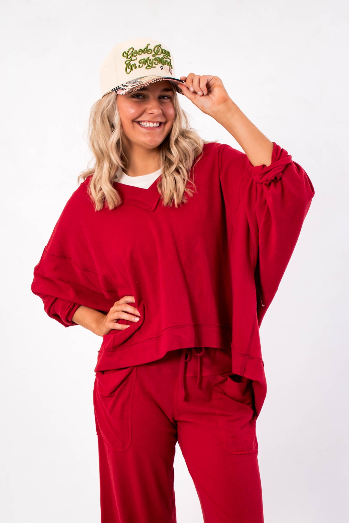 Free People Deep Cherry Staycation Pullover – Cozy oversized V-neck sweatshirt in rich red, styled with matching lounge pants for a relaxed look.
