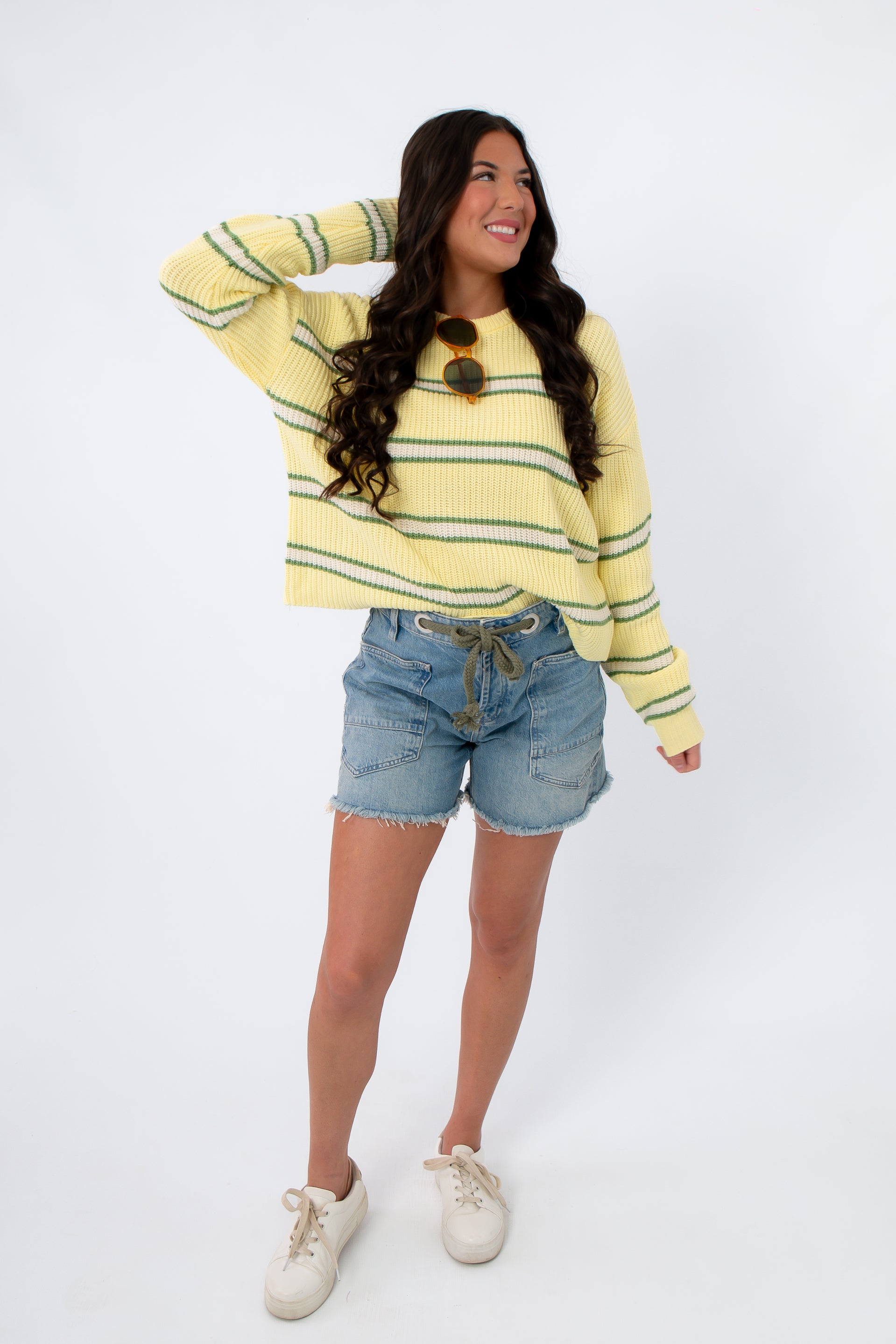 Retro yellow and green striped Country Club Stripe Knit Sweater paired with casual denim shorts. A breathable cotton top for spring and summer outfits.