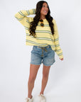 Retro yellow and green striped Country Club Stripe Knit Sweater paired with casual denim shorts. A breathable cotton top for spring and summer outfits.