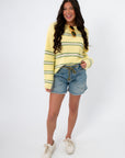 Country Club Stripe Knit Sweater in retro yellow and green stripes styled with denim shorts and white sneakers. Lightweight cotton pullover perfect for spring.