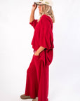 Free People Deep Cherry Staycation Pullover – Side view of loose-fit V-neck top in deep cherry, showcasing draped sleeves and cozy texture.