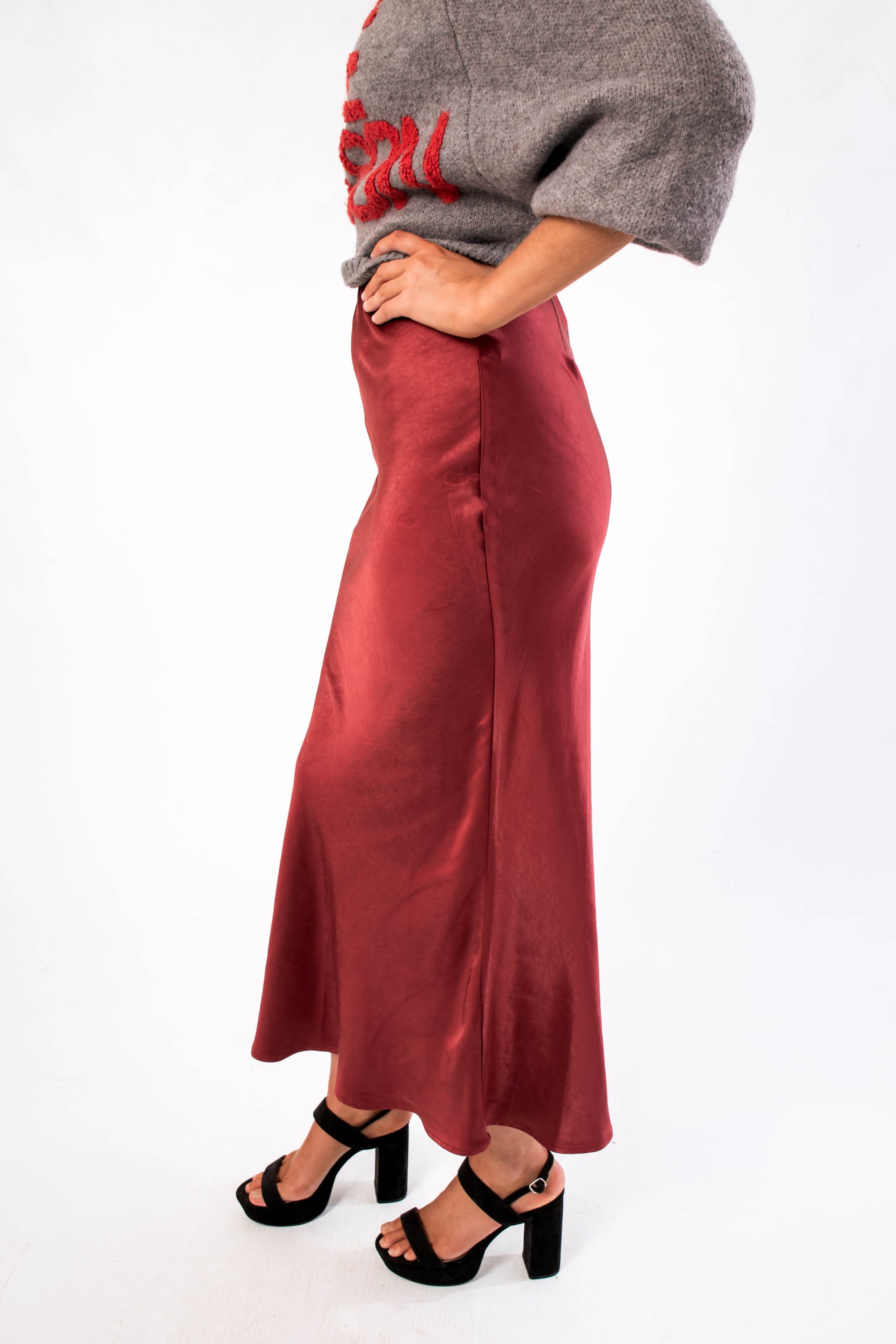 Side view of the Cabernet Crush Satin Midi Skirt highlighting its elegant drape and ankle-length fit for festive occasions.