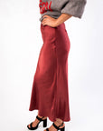 Side view of the Cabernet Crush Satin Midi Skirt highlighting its elegant drape and ankle-length fit for festive occasions.