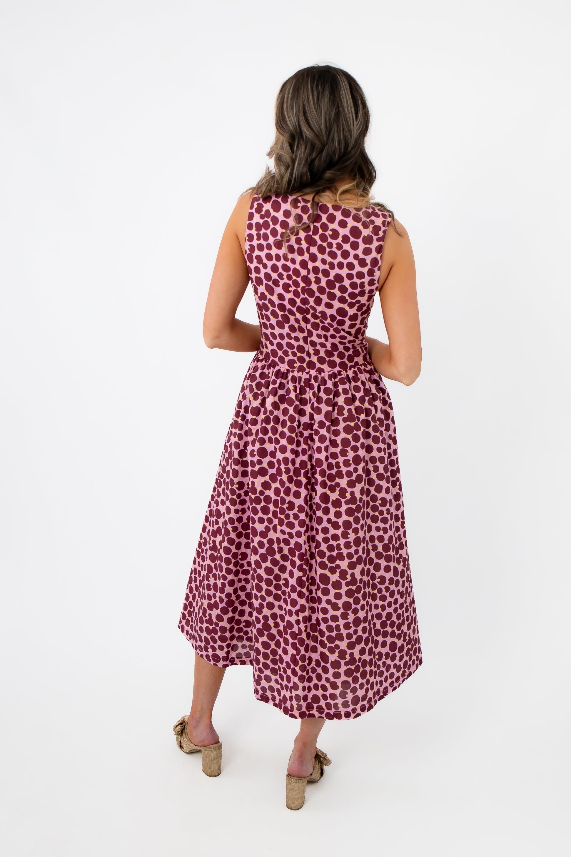 Back view of THML Tini Pink Polka Dot Midi Dress with a cinched waist and flowy midi-length skirt, ideal for stylish summer outings.