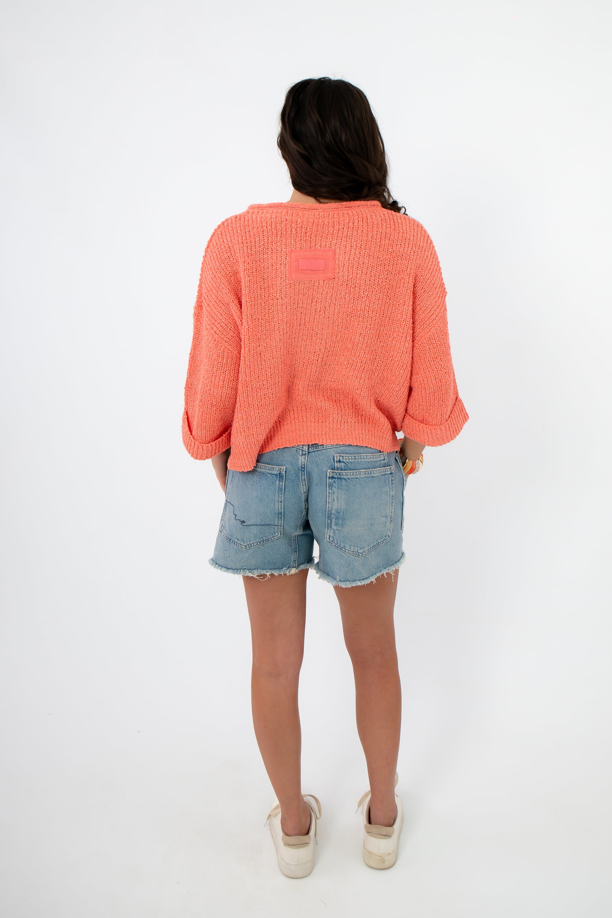 Back view of Papaya Short Sleeve Crop Sweater in coral, styled with denim shorts. Lightweight cropped knit ideal for summer outfits.