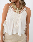 Close-up of lace details and side ties on ivory camisole top