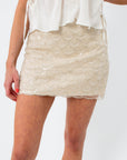 Ivory beaded scalloped mini skirt with sequins, fitted hem, and layered scallop design, perfect for summer occasions