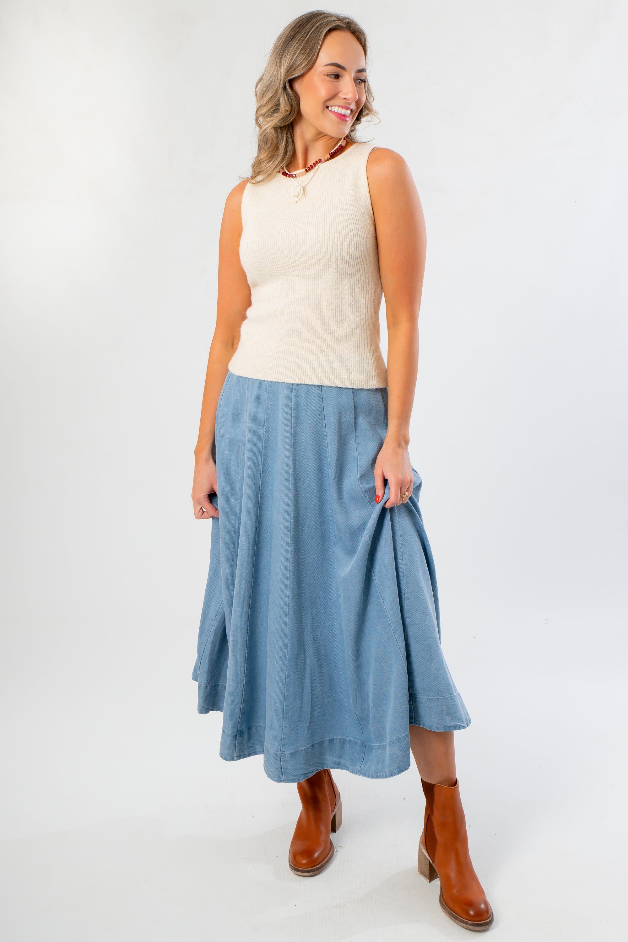 Polly Cream Knit Sleeveless Top with boat neck and long hem, paired with a flowy denim skirt, perfect knit tank for fall layering.