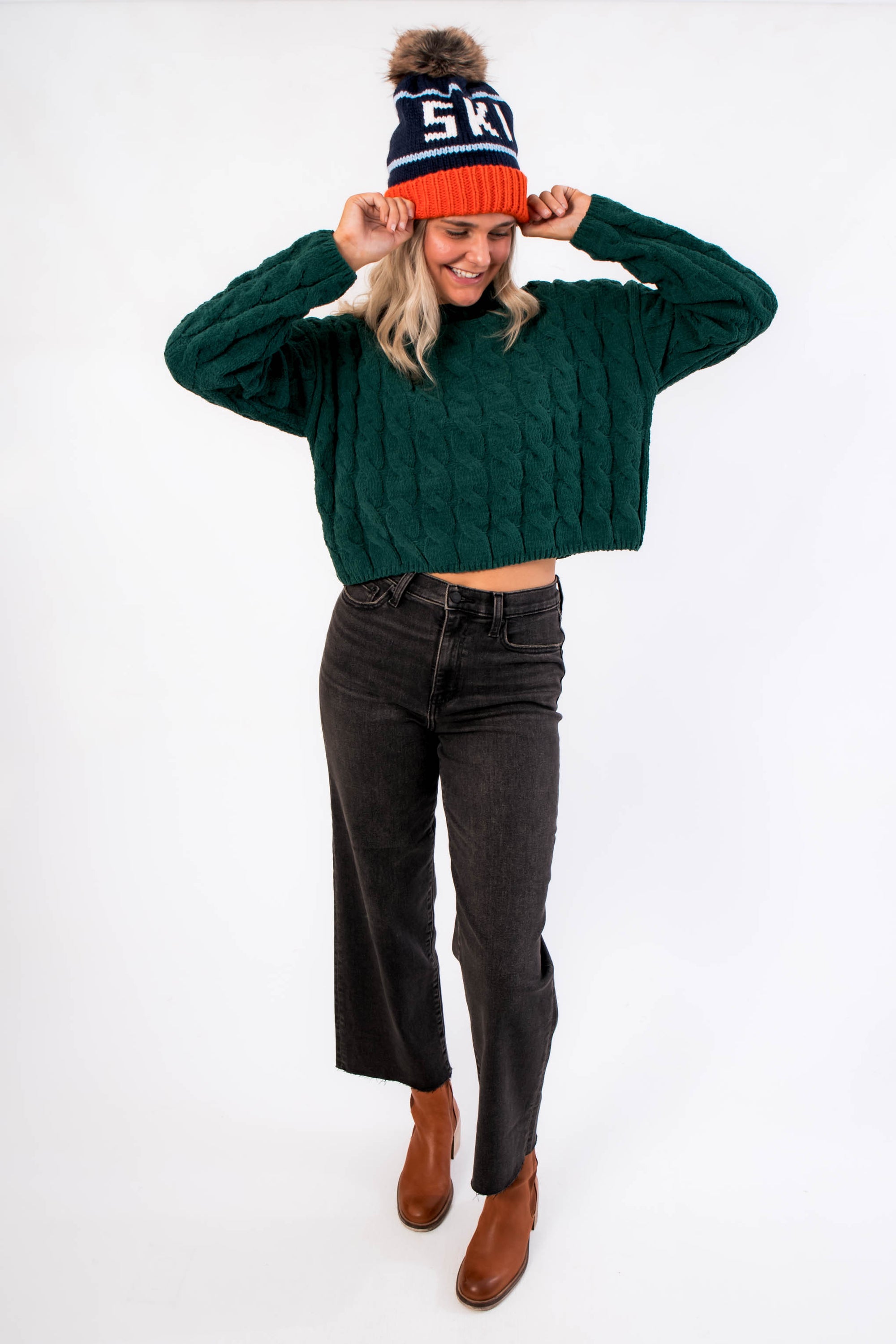 Daze Twilight Pleaser High Rise Wide Ankle Jean in faded black with scissor cut hem, styled with green sweater and brown boots for fall fashion.
