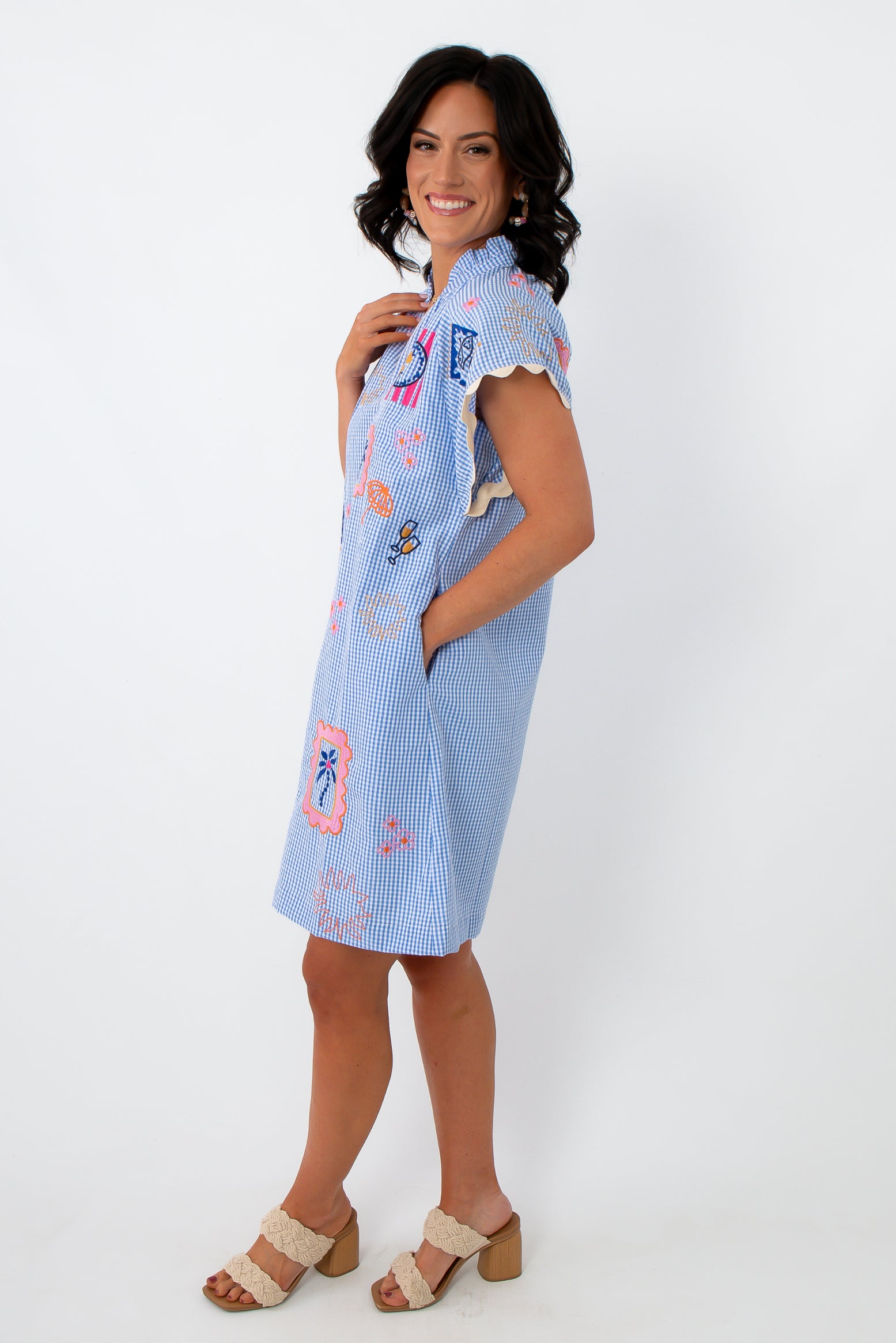 Side view of blue gingham embroidered dress with playful patches, relaxed fit, and pockets for casual summer style
