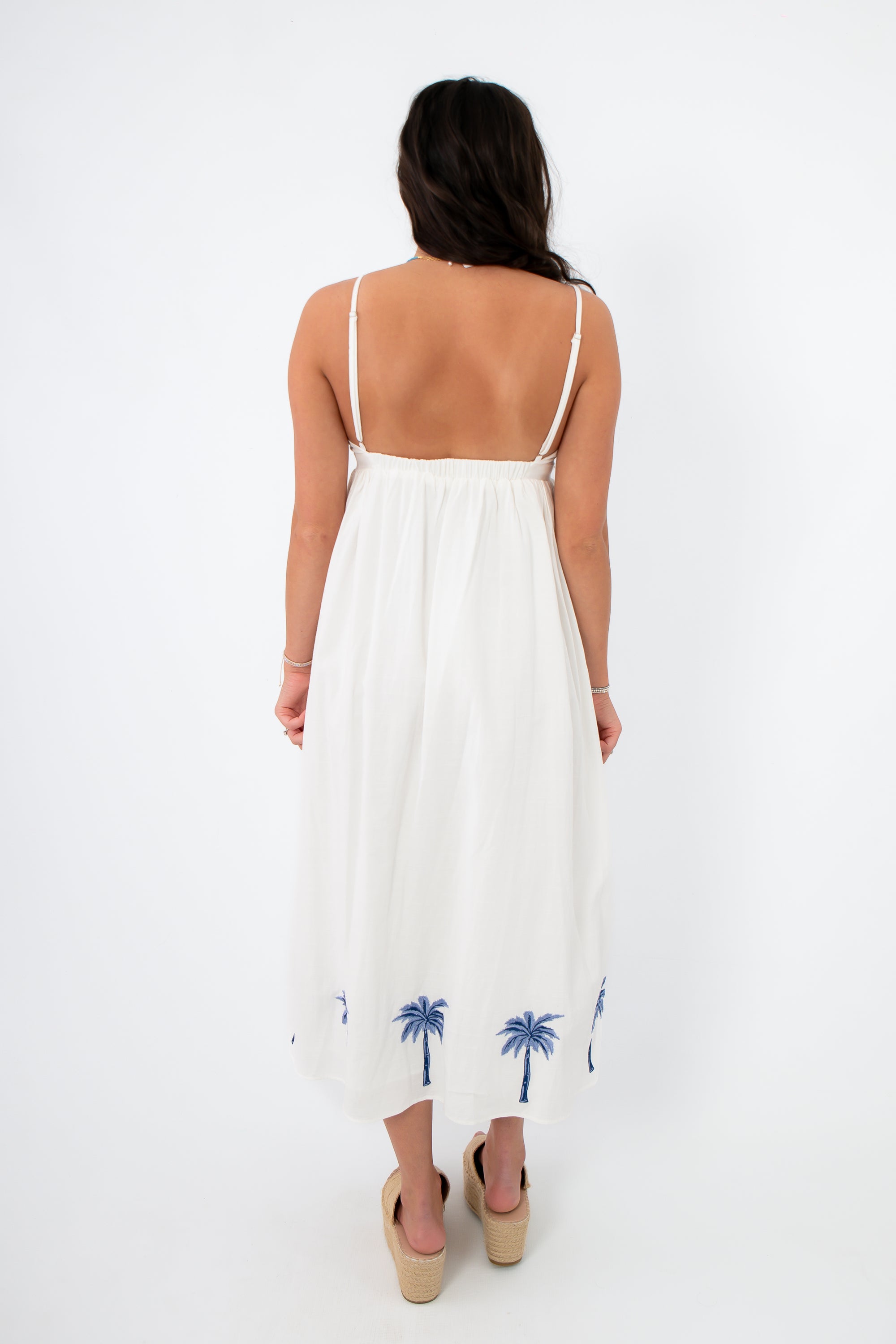 Back view of MINKPINK Isadora Palm Embroidered Midi Dress with open back and elastic waist, ideal for a chic summer vacation look.