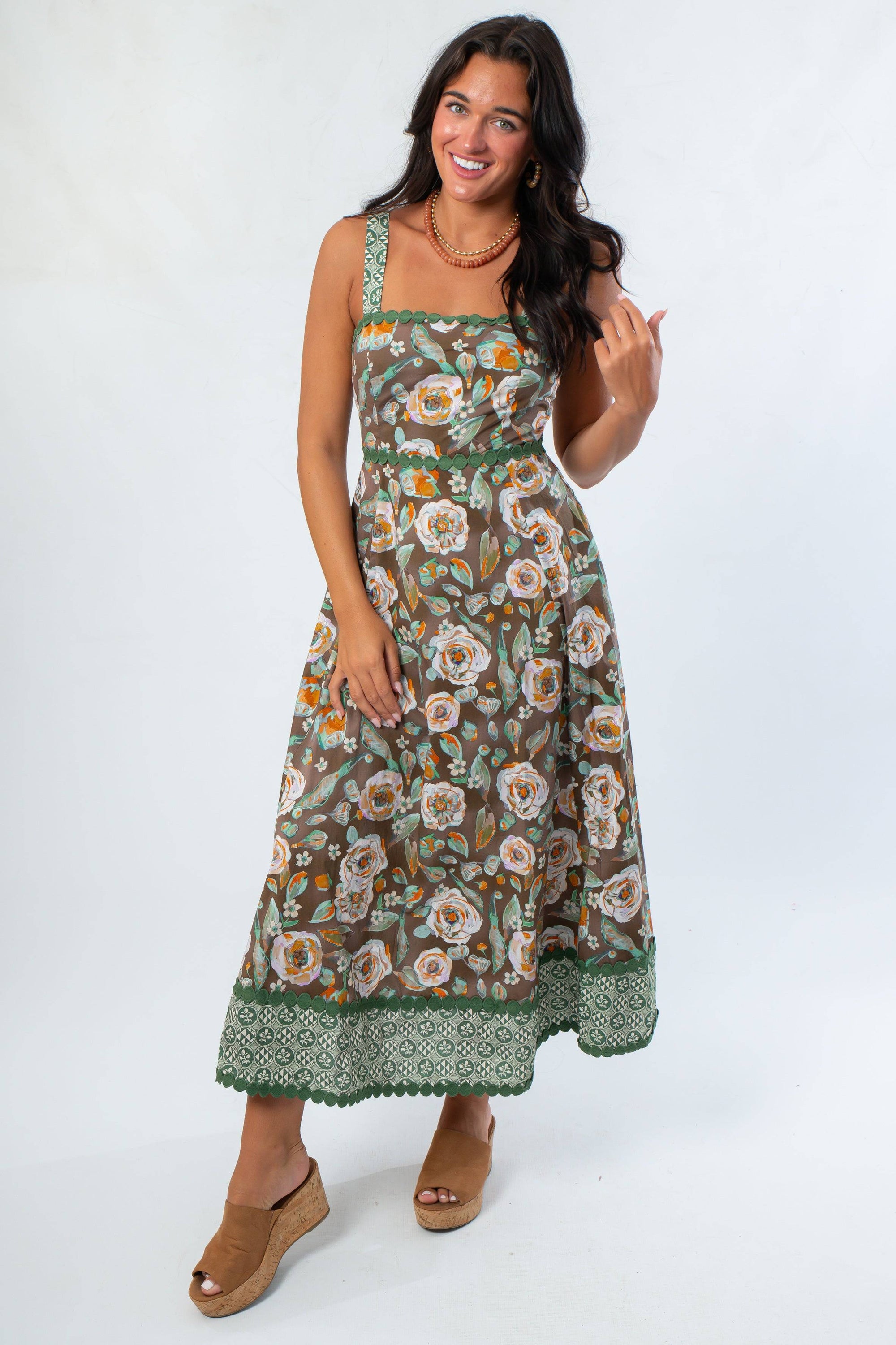 Front view of brown floral midi dress with pockets and green trim, ideal for casual fall outings and Thanksgiving gatherings.