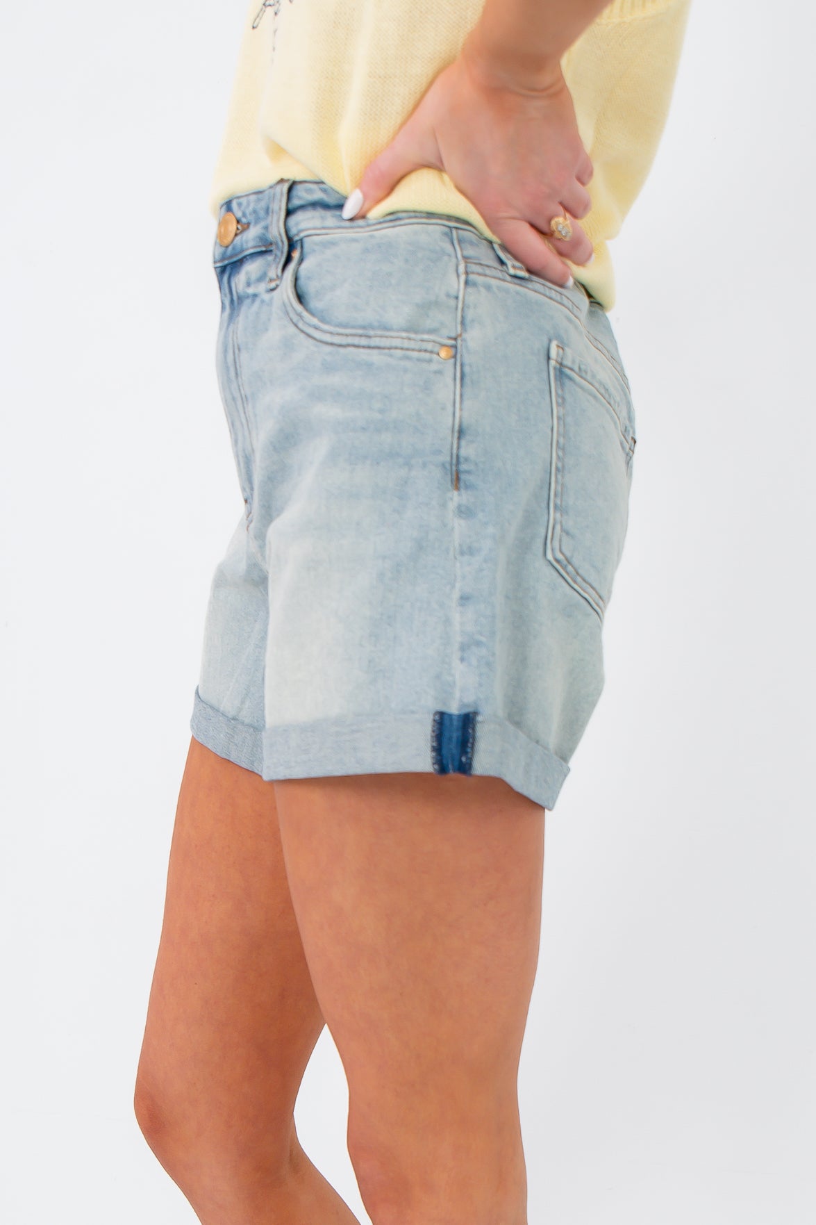 Side view of Kut from the Kloth Wonder Taylor High Rise Short showing light wash denim and rolled cuffs for a casual, flattering fit.
