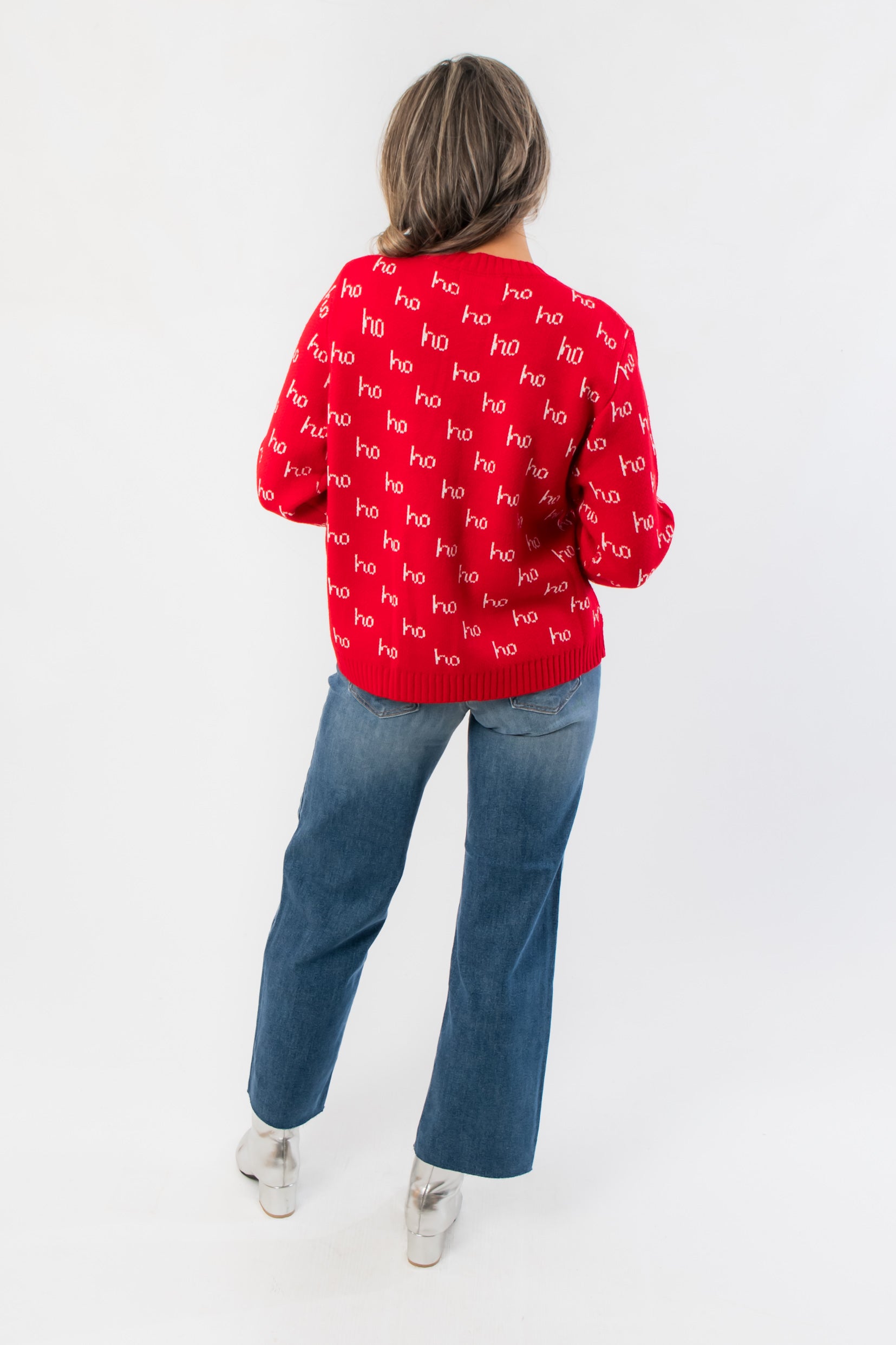 Back view of red Christmas sweater with repeating &#39;ho&#39; print, ribbed cuffs and hem, styled for a cozy boutique holiday look.