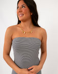 Side view of navy stripe strapless maxi dress with necklace for summer look