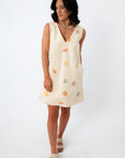 Side view of woman in Coastline Romance beach patterned shift dress with shell and starfish print, styled for summer vacation.