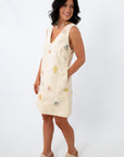 Women modeling Coastline Romance beach patterned shift dress with shell print, eyelet details, and pockets, styled for summer.