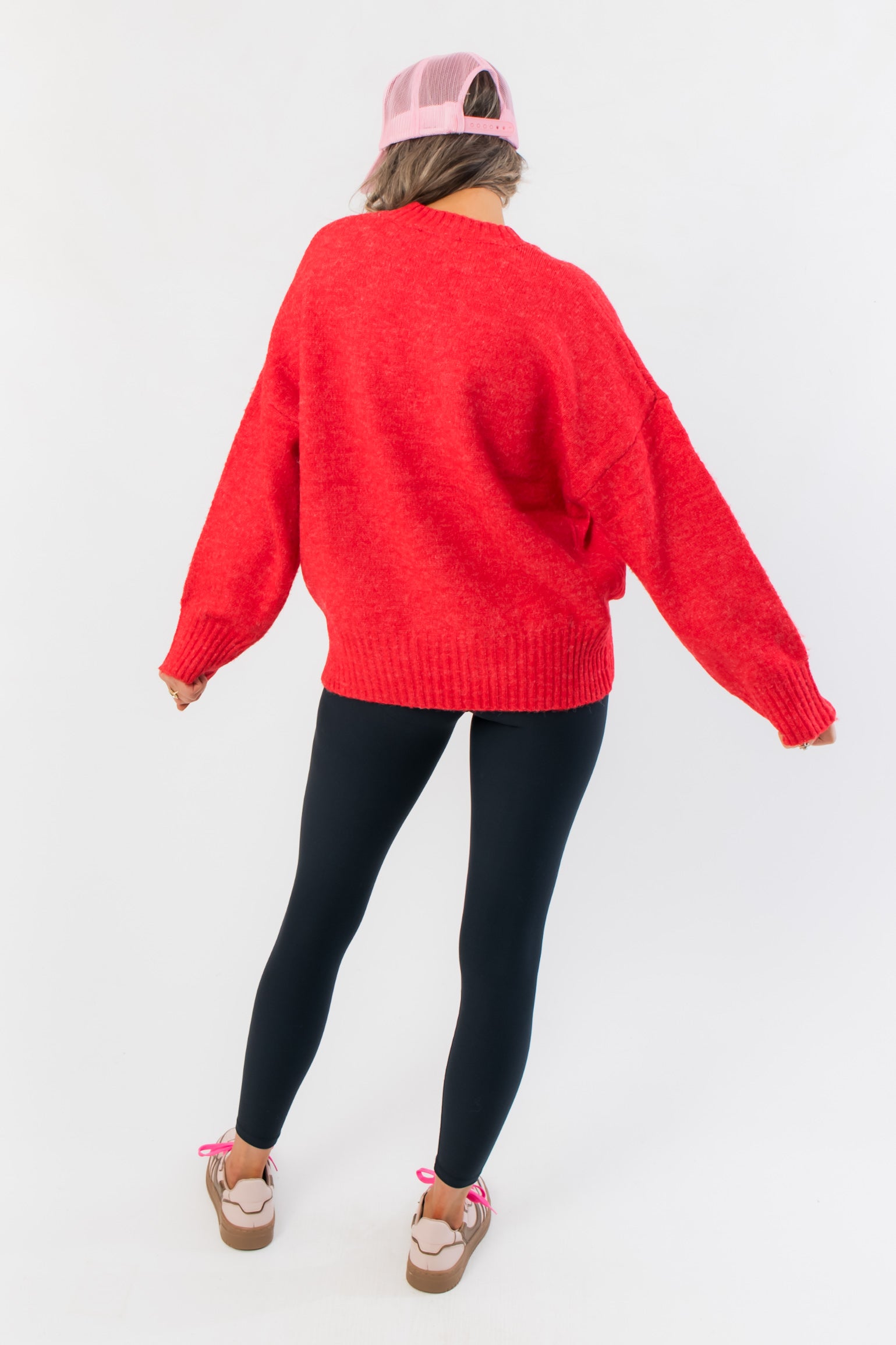 Back view of Candied Cherry Red Knit Sweater highlighting its oversized silhouette and ribbed hem, great for layering in cold weather.