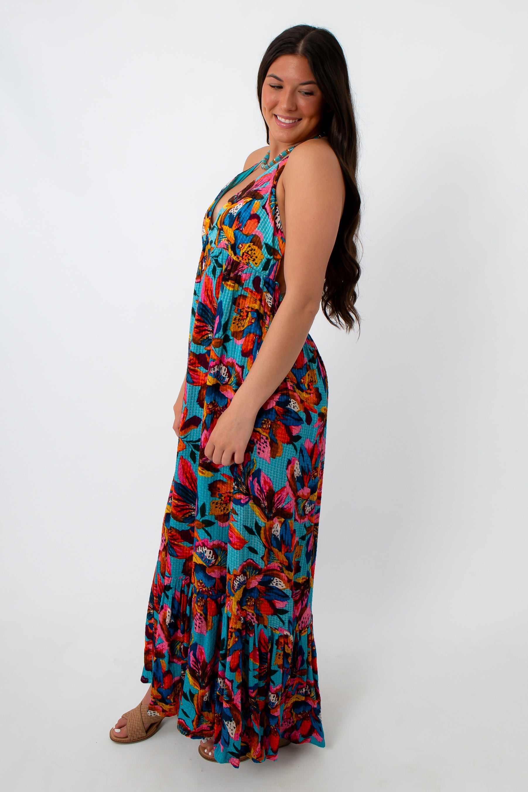 Back view of woman in colorful tropical floral maxi dress