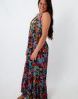 Back view of woman in colorful tropical floral maxi dress