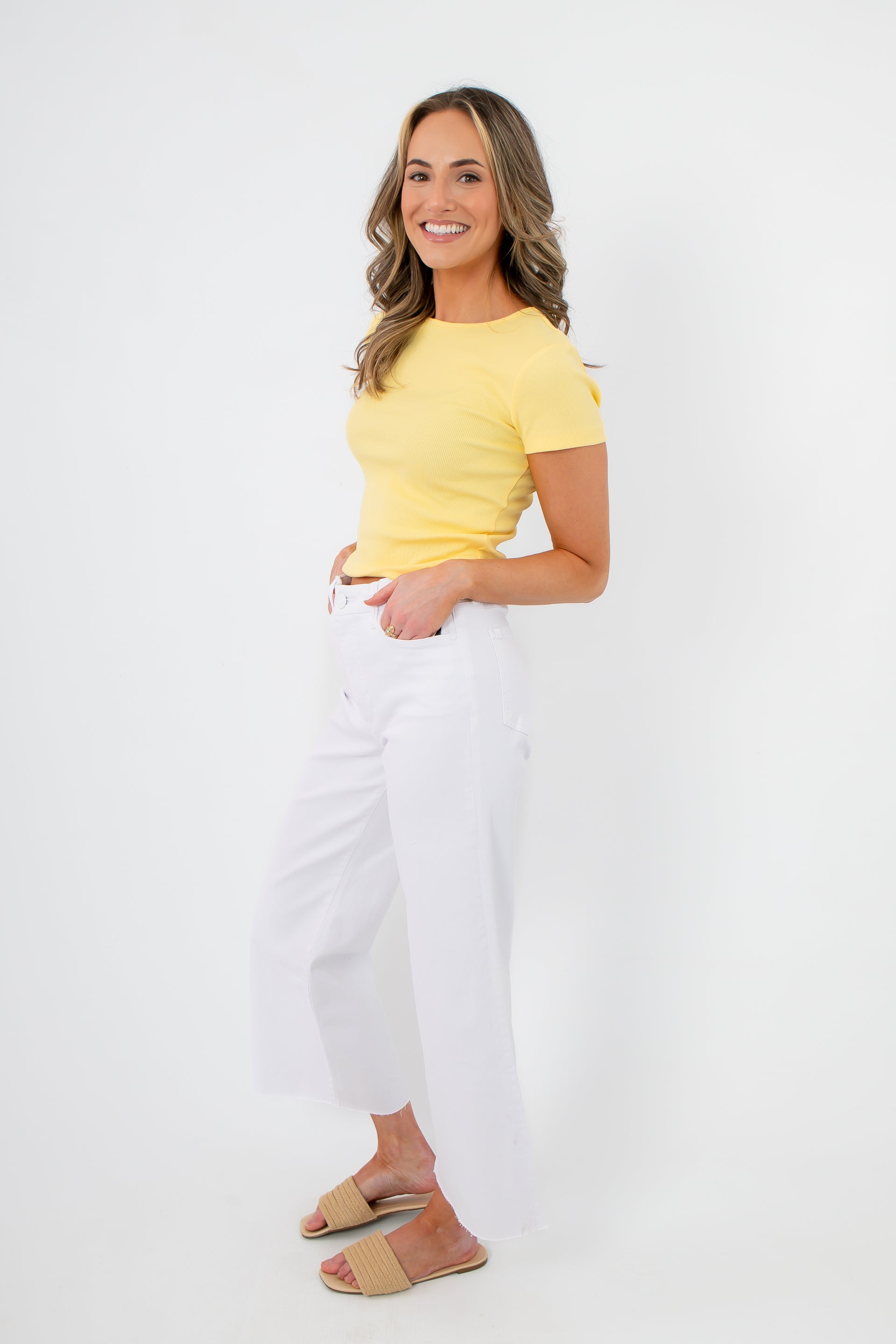Side view of Lemon Drop Essential Short Sleeve Tee paired with wide-leg white pants and sandals, perfect for a relaxed summer outfit.