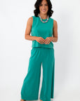 Women wearing teal sleeveless lounge set with wide-leg pants and colorful beaded necklace