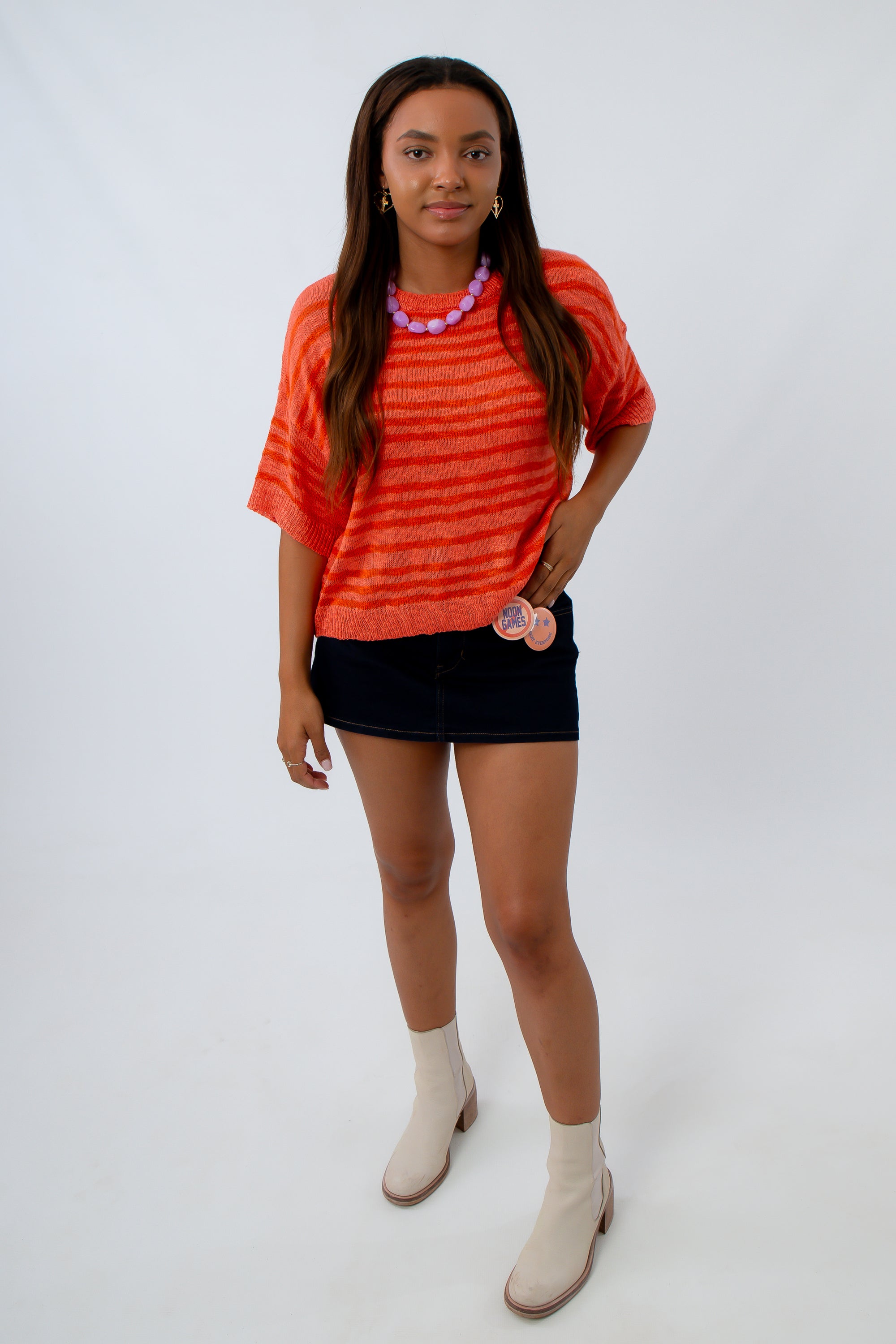 Relaxed fit orange game day sweater with stripes paired with a black mini skort