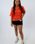 Relaxed fit orange game day sweater with stripes paired with a black mini skort