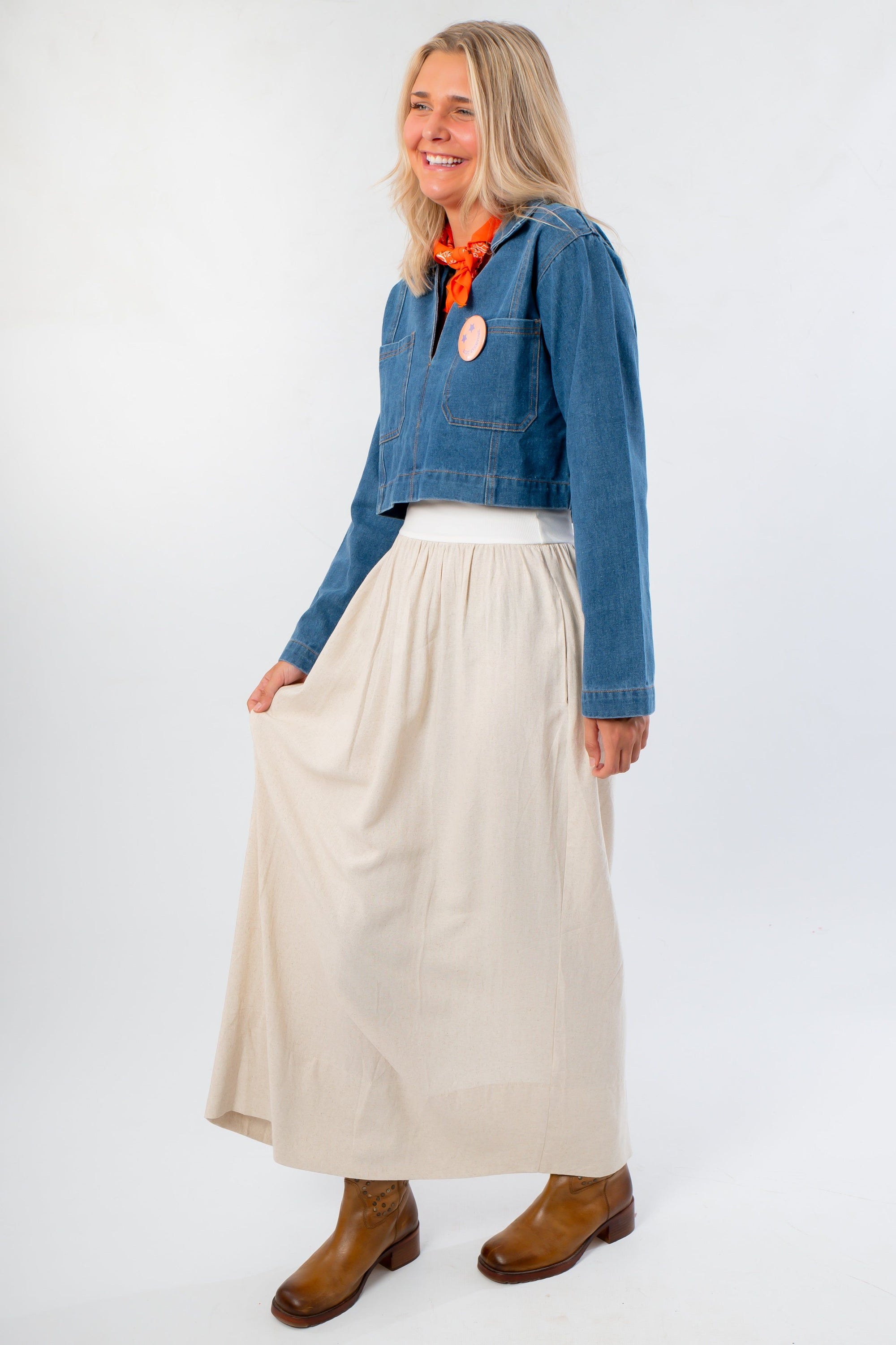 Side view of Denim Long Sleeve Top styled with a cream skirt and brown boots. A versatile, lightweight layering piece for casual outfits.