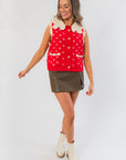 Clara Collared Knit Sweater Vest in red with cream doll collar, styled with olive mini skirt and white ankle boots for festive winter layering.