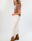 Side profile of It's Gameday Camo Crop Graphic Tee – Stylish Neutral Crop Top highlighting cropped cut and casual fit, worn with a high-waisted cream skirt.