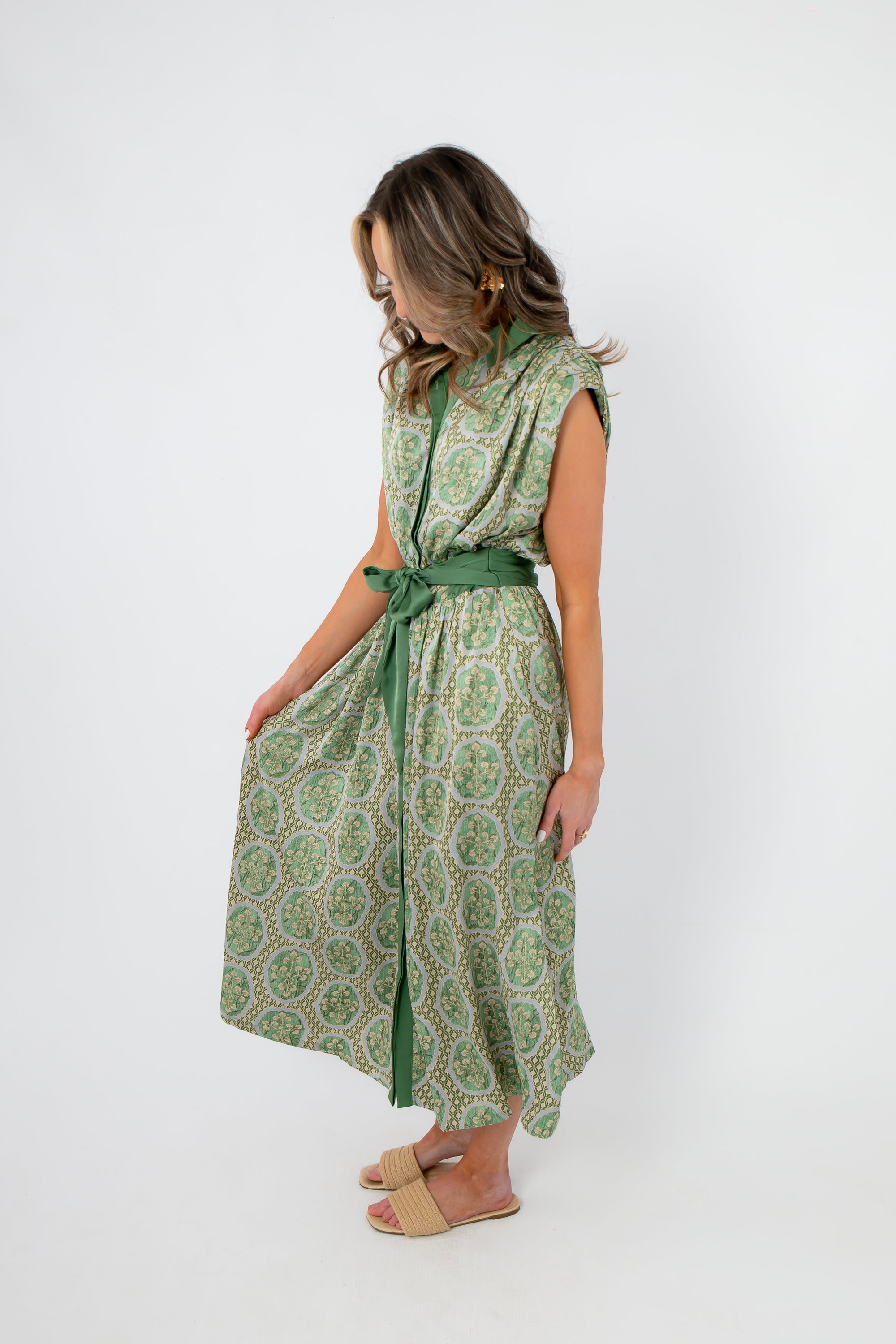 Side view of Art Deco Satin Midi Dress in emerald green with patterned satin and sash belt, great for weddings or polished outings.